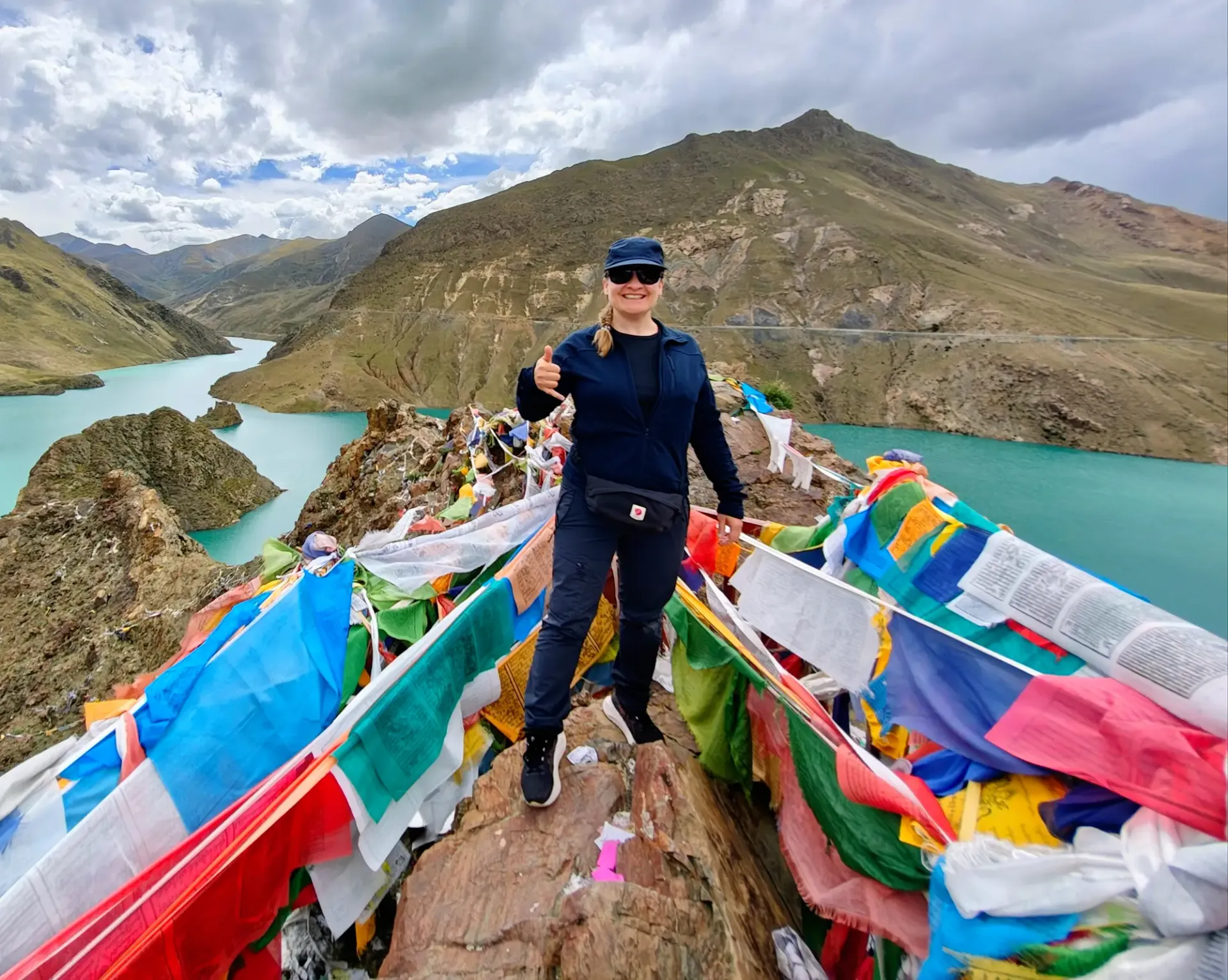Dr. Michaela Musilova on her Astro Seven Summits mission. Standing on the hill, surroinded by the river. Around her are multiple flags.
